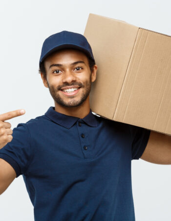 delivery-concept-portrait-happy-african-american-delivery-man-pointing-hand-present-box-package-isolated-grey-studio-background-copy-space